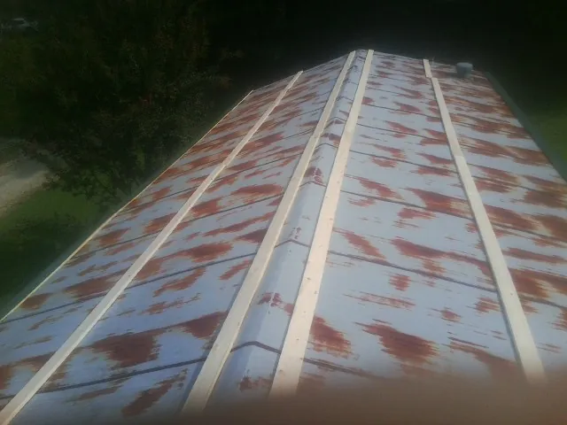 Rusted metal roof panels with new wood purlins before replacement — Storm Damage Roof Repair in Rye by Roofing Brothers
